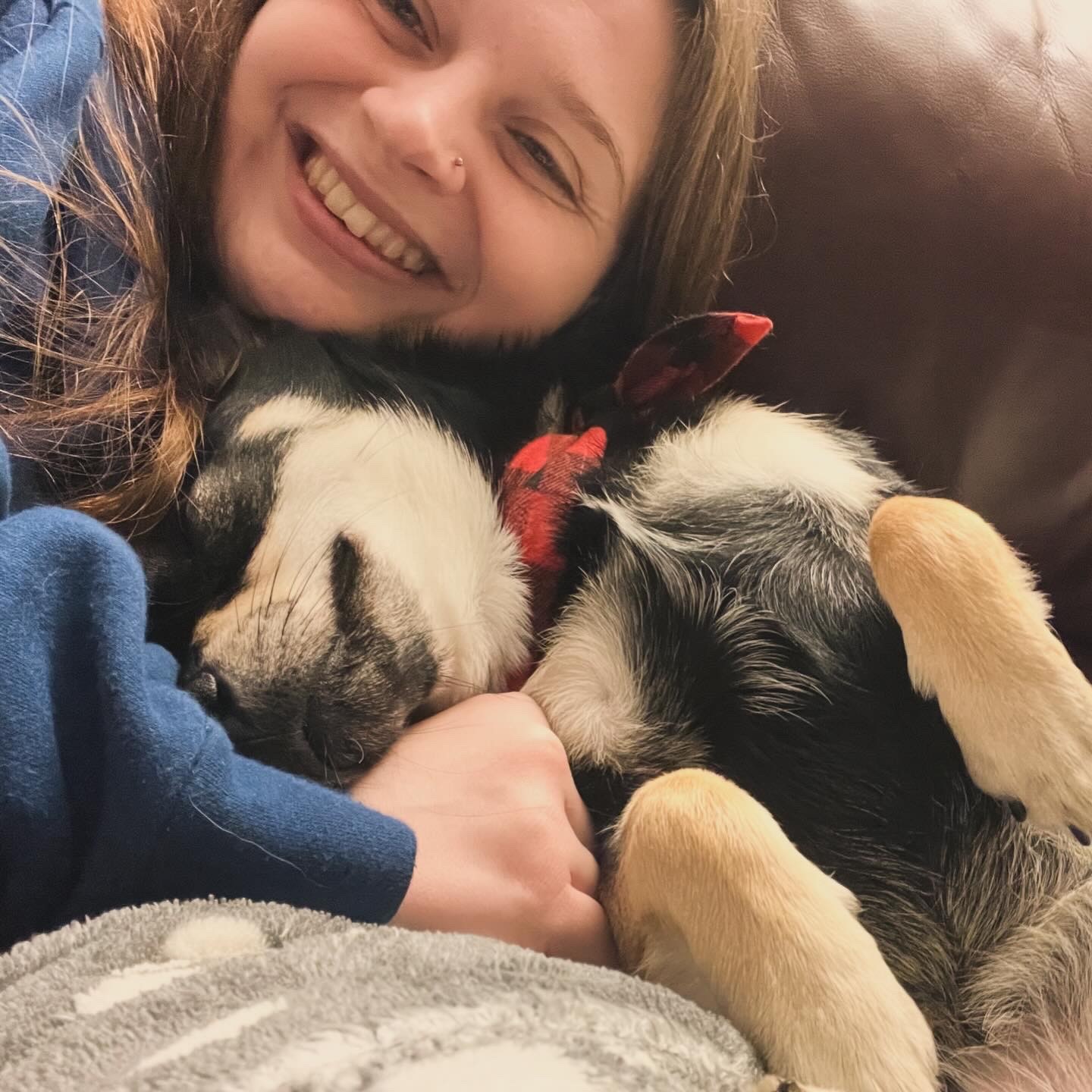Photo of Beth smiling whilst having a cuddle with Fabio